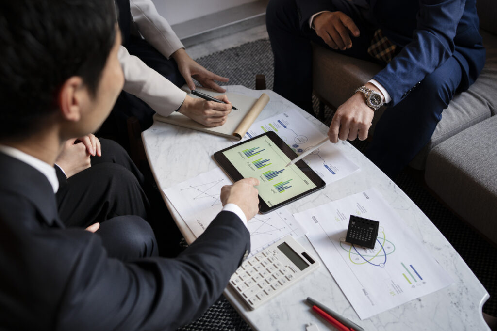 Réunion d'équipe analysant des graphiques sur tablette.