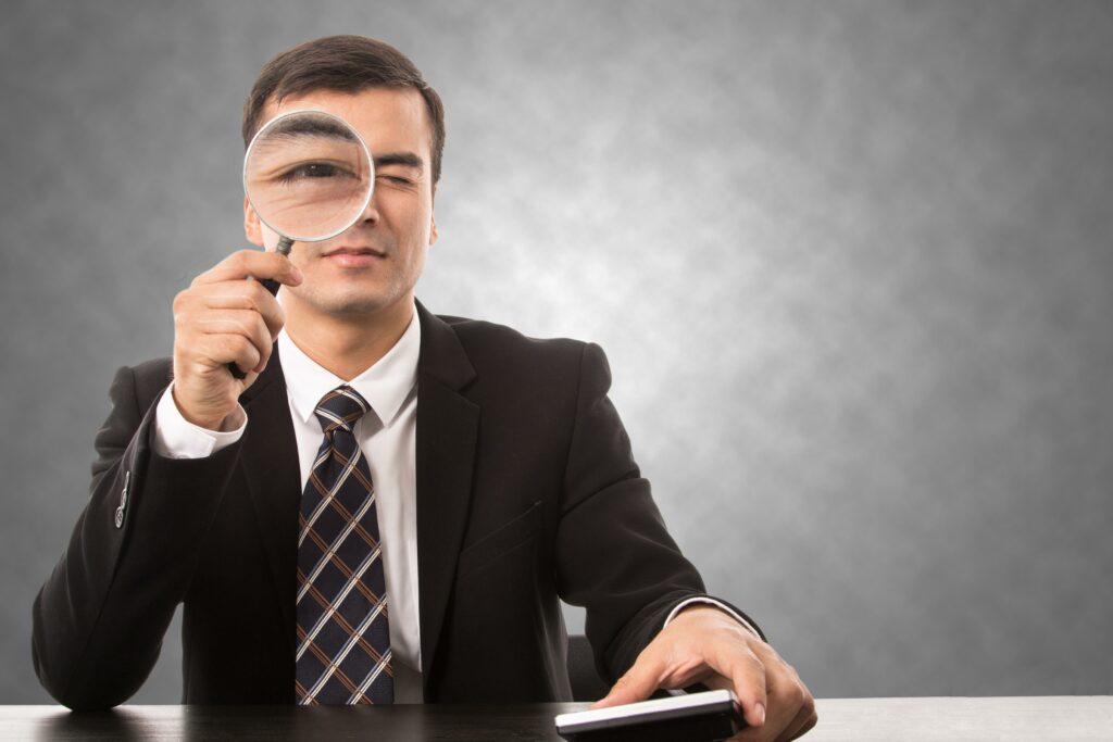 Homme en costume avec loupe sur l'œil