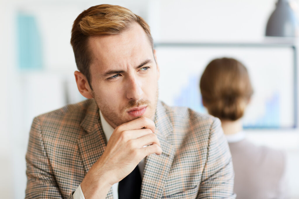 Homme pensif en costume au bureau.