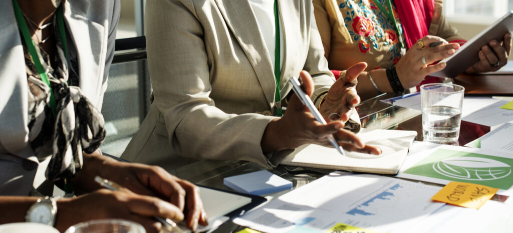 Réunion professionnelle avec documents et tablettes.