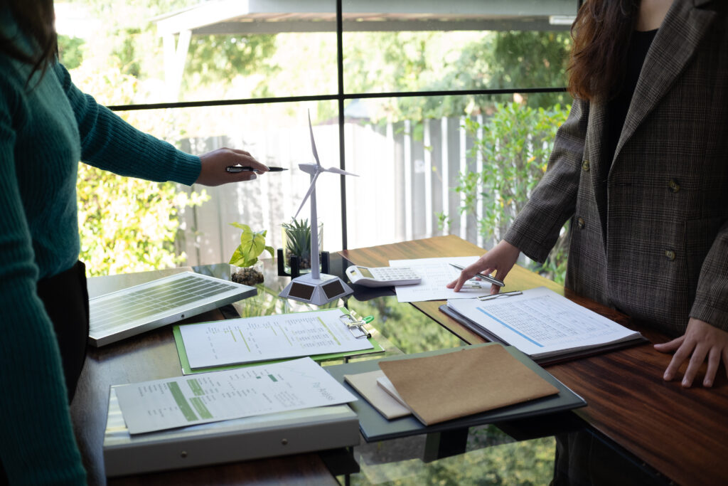 Réunion autour de documents et maquette éolienne.