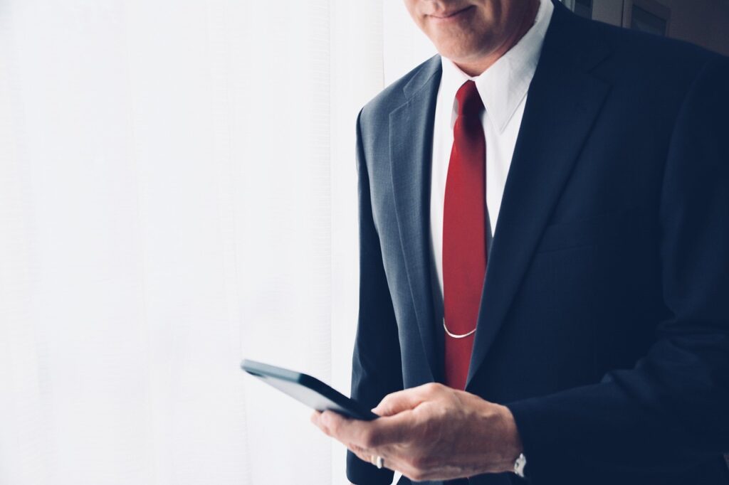 Homme en costume utilisant un smartphone.