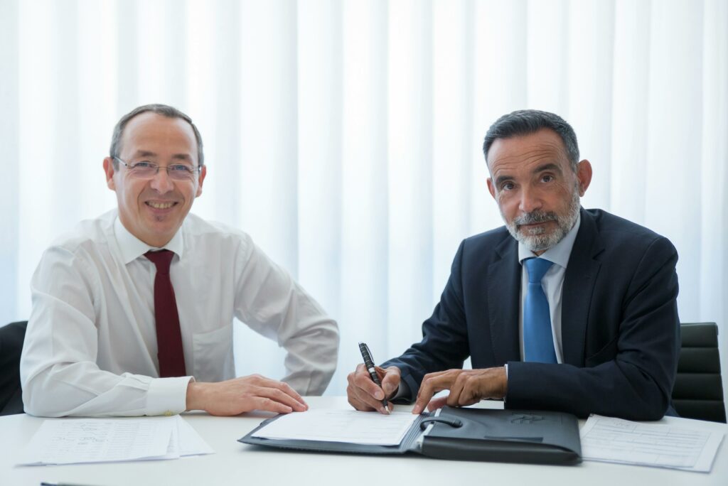 Deux hommes signent des documents.